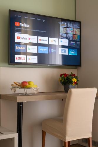 a television on a wall with a table and a chair at B&B Accademia in Verona