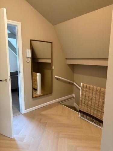a bathroom with a mirror and a wooden floor at Naest - Authentic Escapes Grand House in Nijmegen