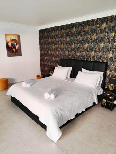 a bedroom with a large bed with white sheets at Verdizela Suites in Corroios