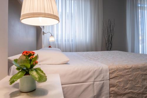 a bedroom with a bed with a vase of flowers on a table at B&B Accademia in Verona