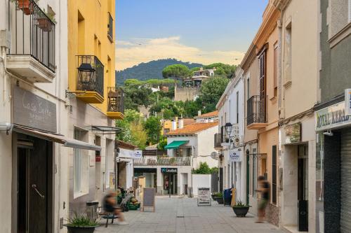 a group of people walking down a street with buildings at L'Hostalet de Cabrils in Cabrils