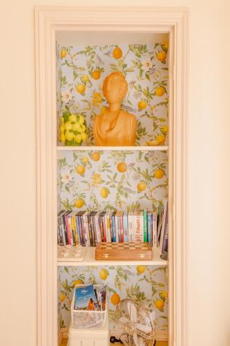 a book shelf with a statue of a person on it at Les Fontaines Saint-Paul-de-Vence Free Parking in Saint-Paul-de-Vence