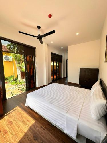 a bedroom with a large bed with a ceiling fan at Hoa Cau HoiAn in Cam Thanh