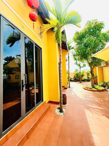a yellow building with a palm tree in front of it at Hoa Cau HoiAn in Cam Thanh