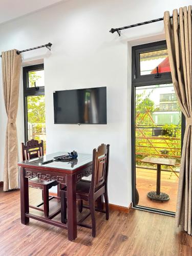 a dining room with a table and a tv at Hoa Cau HoiAn in Cam Thanh