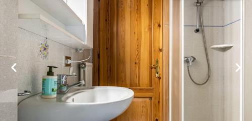 a bathroom with a white sink and a shower at Casa Martini in Mezzana