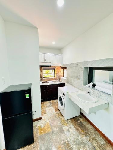 a kitchen with a sink and a washing machine at Hoa Cau HoiAn in Cam Thanh