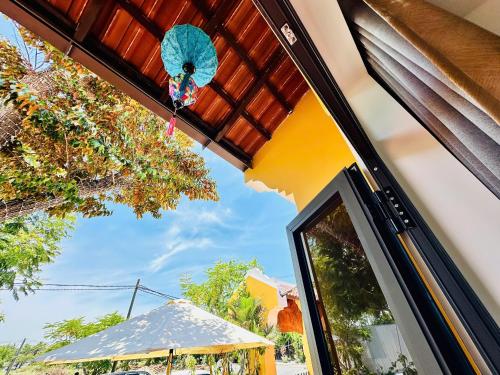 a window of a house with a blue umbrella at Hoa Cau HoiAn in Cam Thanh
