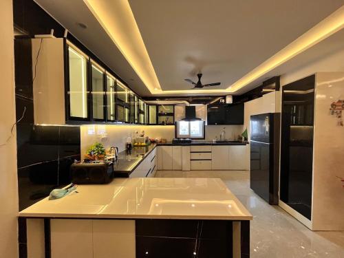 a large kitchen with white cabinets and a ceiling at Veda- Luxurious 4BHK with Ganga & Hill View in Rishīkesh