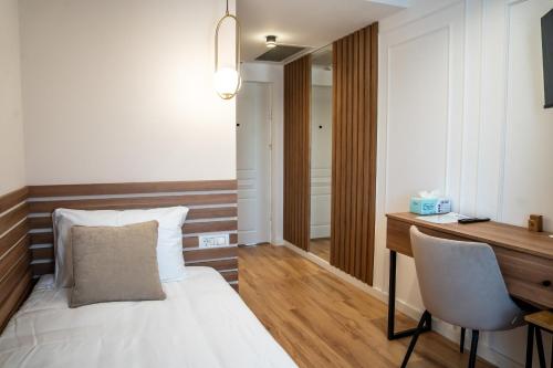 a bedroom with a bed and a desk and a chair at Volotel SkyWay in Cluj-Napoca