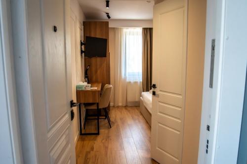 a small room with a desk and a bedroom at Volotel SkyWay in Cluj-Napoca