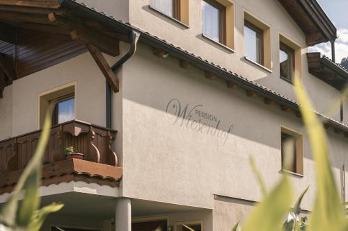 a building with a balcony on the side of it at Pension Wiesenhof in Campo di Trens