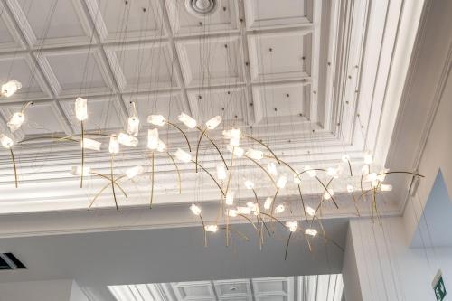 a chandelier with white flowers hanging from a ceiling at The Spotlight Boutique Hotel in Rome