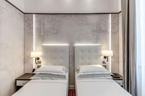 two beds sitting next to each other in a room at The Spotlight Boutique Hotel in Rome