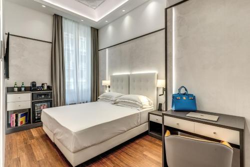 a bedroom with a bed and a desk with a blue bag at The Spotlight Boutique Hotel in Rome