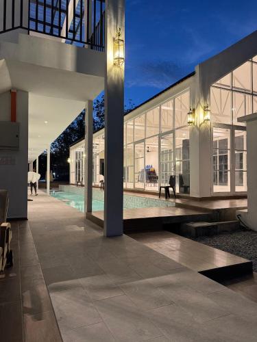 a large white house with a courtyard with a bench at The Outskirt Melaka in Kampong Lendu