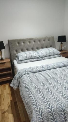 a large bed in a bedroom with two lamps at Apartmani Katnic in Jagodina