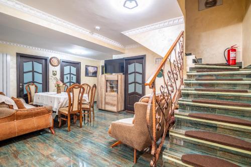 a room with a staircase and a table and chairs at Casa Nicolas Busteni in Buşteni