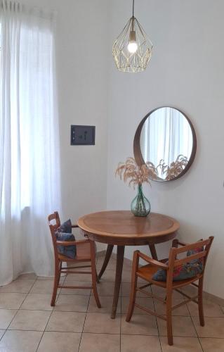 a dining room table with a mirror and two chairs at La Terrazza Apartment,a 50 mt dal mare in Varazze