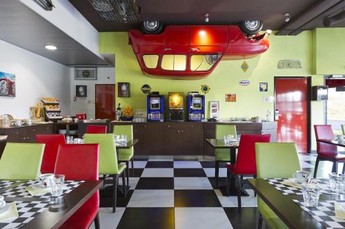 a restaurant with a checkered floor and tables and chairs at Enzo Hotels Thionville by Kyriad Direct in Thionville