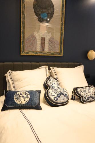 un letto con due cuscini bianchi e blu di Li li et rose - Suite avec jacuzzi privatif a Nantes
