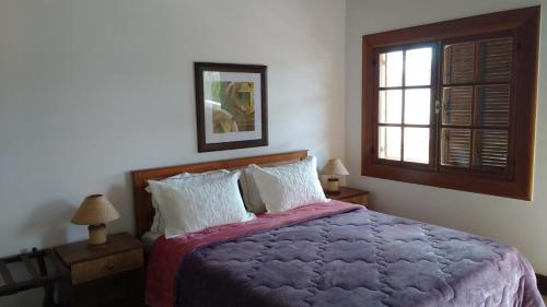 a bedroom with a large bed and a window at 3 Palmeiras Guest Lounge in Miguel Pereira