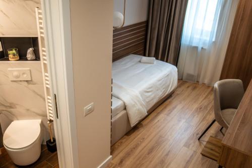 a small room with a bed and a toilet at Volotel SkyWay in Cluj-Napoca
