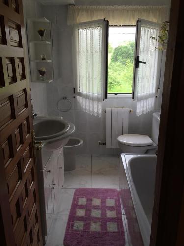 uma casa de banho com um lavatório, uma banheira e um WC. em Casa Mariana em Llames de Parres