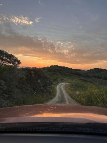 a car driving down a dirt road at sunset at Cabana Vatra Sloveanu 
