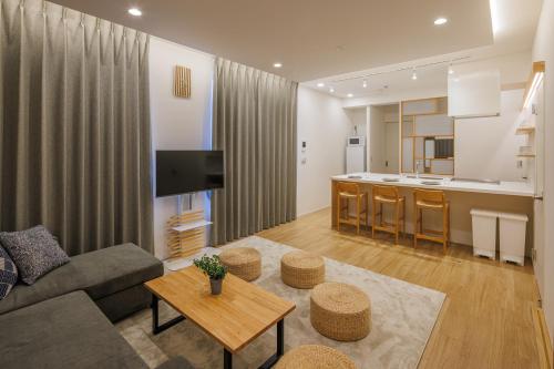 a living room with a couch and a table and a kitchen at Tokyo Sky Suite Hotel in Tokyo