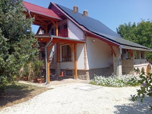 a house with a red roof and a yard at Hagyományőrző és múltidéző porta in Báta