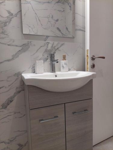 a bathroom with a sink and a mirror at Natasa's Appartment in Kalamata in Kalamata
