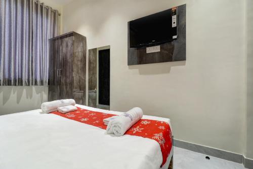 ナビムンバイにあるHotel Royal Inn Nerulのベッドと薄型テレビのある寝室