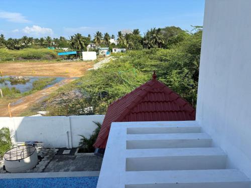 a stairway with a red roof next to a building at Grandir Inn Villa in Mahabalipuram