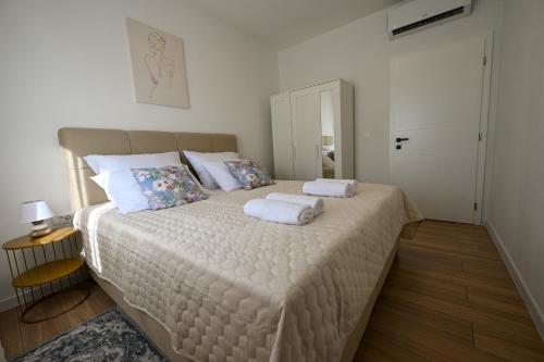 a bedroom with a large bed with two towels on it at Villa Zara Blu with pool in Briševo