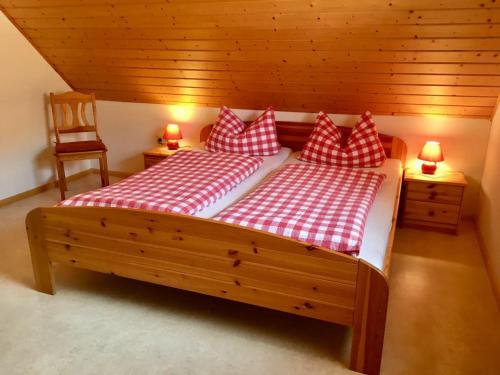 Un dormitorio con dos camas con almohadas rojas y blancas. en Felsenhof Simonswald, en Simonswald