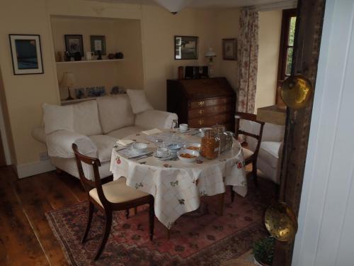 a living room with a table and a couch at Kipps Farm in Great Torrington