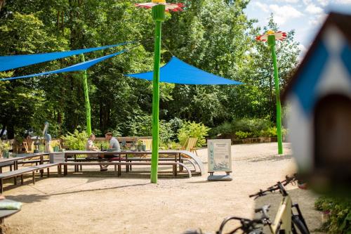 two people sitting on a park bench under blue umbrellas at Gästesuite im Stöckelkeller bei Bayreuth 