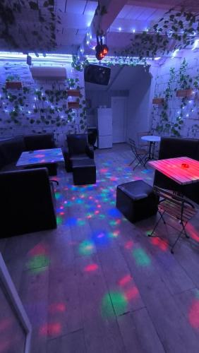 a room with a table and chairs and lights on the floor at cunami kucica in Belgrade