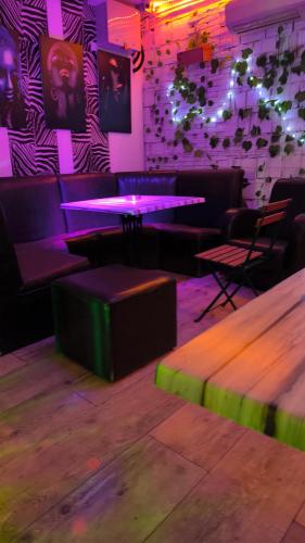 a restaurant with purple and green lighting and tables at cunami kucica in Belgrade