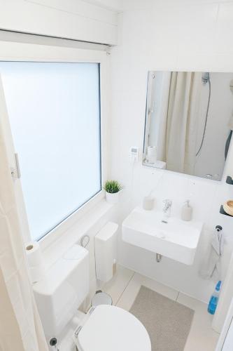 a white bathroom with a sink and a toilet at Dein Ferienhaus in Andernach