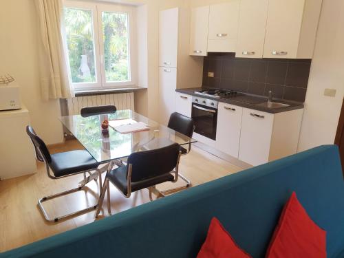a kitchen with a glass table and chairs in a room at Villa dei Fiori in Luino