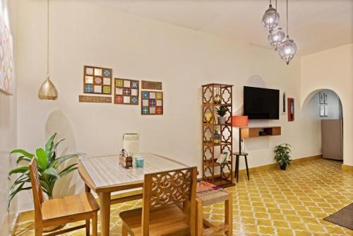 a living room with a table and a tv at Blissful Stay, LUX Suites & Tint of Mint - 1 BHK Apartment, 5min Beach, Auroville Pondicherry in Kottakupam