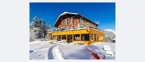 a large yellow building in the snow with snow at Domaine de Rozan - Col de Porte, Chartreuse - Grenoble in Sarcenas