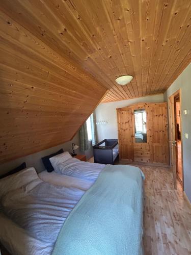 a bedroom with two beds and a wooden ceiling at Sognefjorden-Vik i Sogn in Brekka