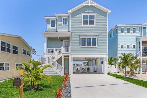 una grande casa con una scala davanti di 209 Seabreeze Escape- NEW Spacious 5-Bedroom Pool Home home a Fort Myers Beach