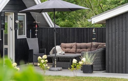 VestervigにあるCozy Home In Vestervig With Wifiのパティオ(ソファ、テーブル、パラソル付)