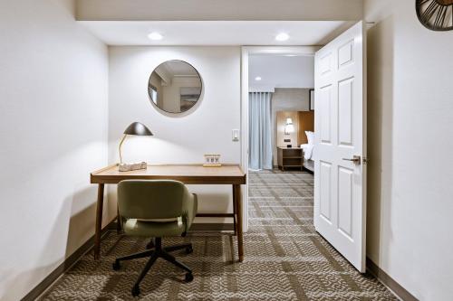 a room with a desk and a chair and a mirror at Staybridge Suites Oxnard - River Ridge by IHG in Oxnard
