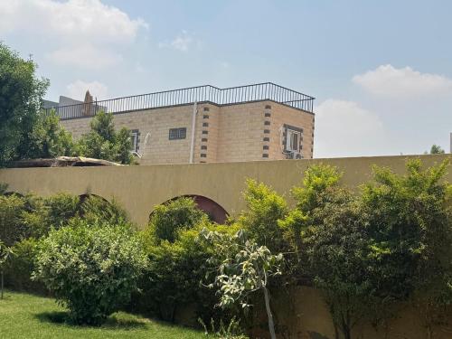 a building on top of a bridge with trees at Pyramids Green View in Cairo
