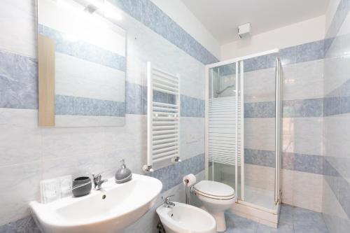Un baño con lavabo, inodoro y ducha. en Dream House Fiumicino, en Fiumicino